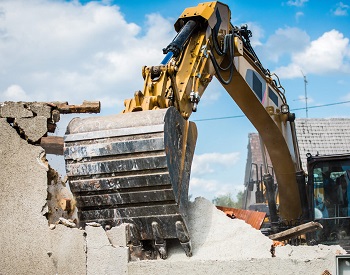 excavator tearing down a building