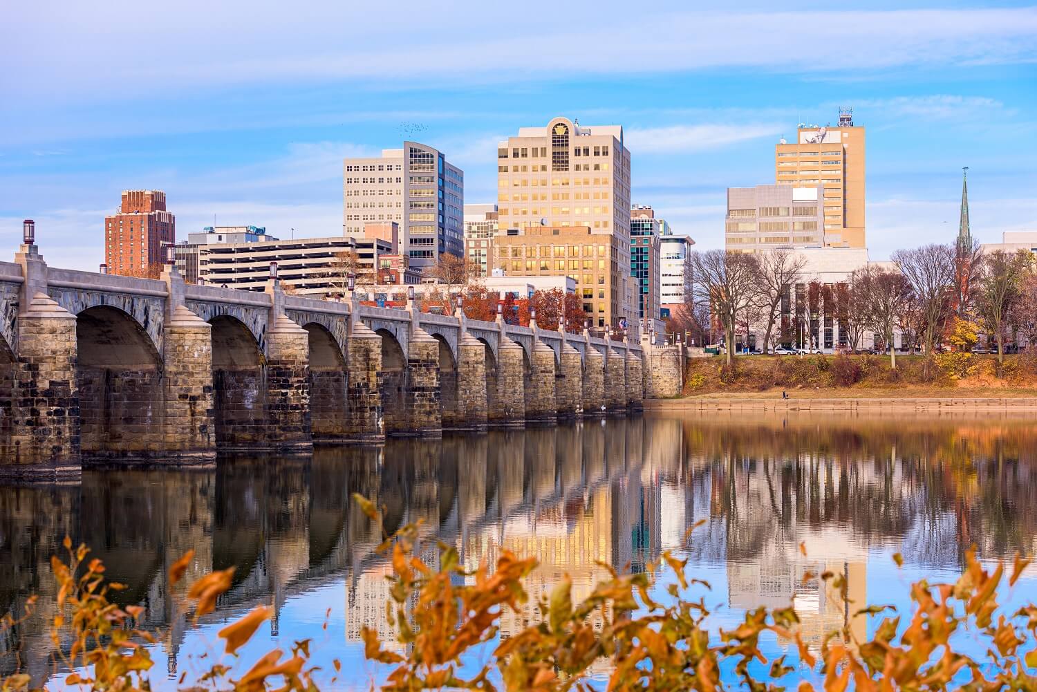 river with a bridge that goes across into a city