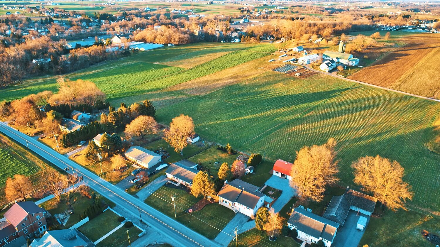 houses with farming fields behind them