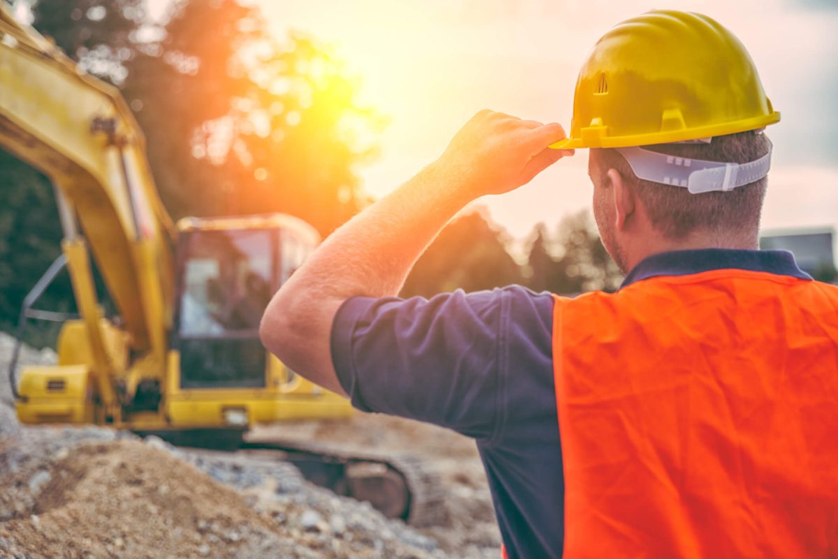 worker looking at an excavator