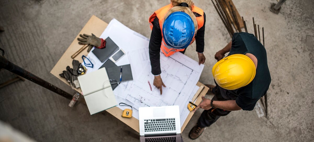 two workers looking at blueprints