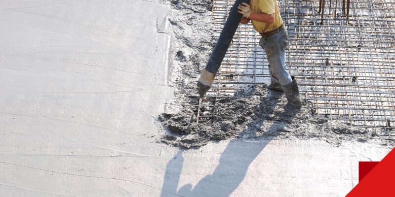worker pouring concrete onto foundation